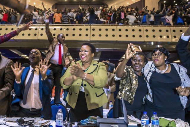 Zimbabwe's members of parliament celebrate after Mugabe's resignation on November 21, 2017 in Harare. Robert Mugabe resigned as president of Zimbabwe on November 21, 2017 swept from power as his 37-year reign of brutality and autocratic control crumbled within days of a military takeover. The bombshell news was delivered by the parliament speaker to a special joint session of the assembly which had convened to impeach Mugabe, 93, who has dominated every aspect of Zimbabwean public life since independence in 1980.  / AFP PHOTO / Jekesai NJIKIZANA