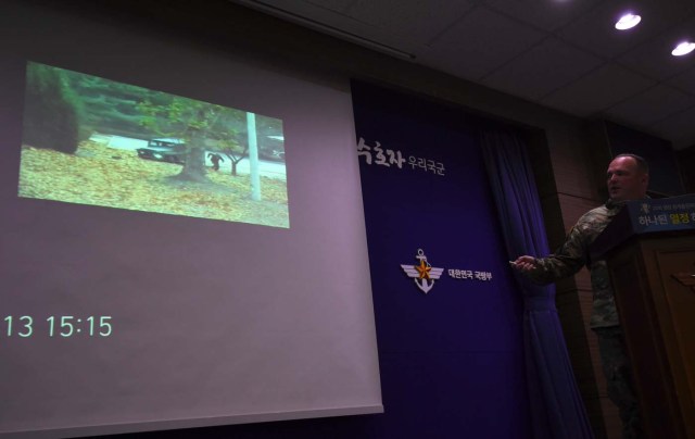 United Nations Command spokesman Colonel Chad G. Carroll shows a surveillance TV footage containing the moment of defection of a North Korean Soldier, during a press briefing at the Defence Ministry in Seoul on November 22, 2017. A North Korean soldier crossed the border into the South in breach of a 1953 armistice agreement as he pursued a defector who was shot last week, the US-led United Nations Command (UNC) said on November 22. / AFP PHOTO / JUNG Yeon-Je