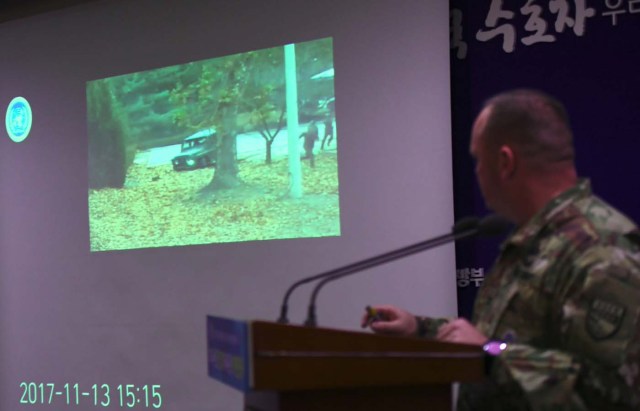 United Nations Command spokesman Colonel Chad G. Carroll shows a surveillance TV footage containing the moment of defection of a North Korean Soldier, during a press briefing at the Defence Ministry in Seoul on November 22, 2017. A North Korean soldier crossed the border into the South in breach of a 1953 armistice agreement as he pursued a defector who was shot last week, the US-led United Nations Command (UNC) said on November 22. / AFP PHOTO / JUNG Yeon-Je