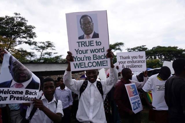 People gather outside Harare's airport to welcome former Zimbabwean vice-president Emmerson Mnangagwa on November 22, 2017 in Harare. Mnangagwa, 75, was sacked by the president on November 6 in a move that pushed infuriated army chiefs to intervene, triggering a series of events which led to Mugabe's ouster. Nicknamed "the Crocodile" for his ruthlessness, Emmerson Mnangagwa who will take over as Zimbabwe's next president, is a hardliner with ties to the military who could prove as authoritarian as his mentor Robert Mugabe. / AFP PHOTO / ZINYANGE AUNTONY
