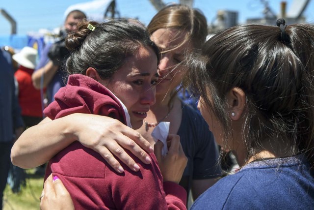 A relative of one of the 44 crew members of Argentine missing submarine, is comforted outside Argentina's Navy base in Mar del Plata, on the Atlantic coast south of Buenos Aires, on November 23, 2017. An unusual noise heard in the ocean near the last known position of the San Juan submarine was "consistent with an explosion," Argentina's navy announced Thursday. "An anomalous, singular, short, violent and non-nuclear event consistent with an explosion," occurred shortly after the last communication of the San Juan and its 44 crew, navy spokesman Captain Enrique Baldi told a news conference in Buenos Aires. / AFP PHOTO / EITAN ABRAMOVICH