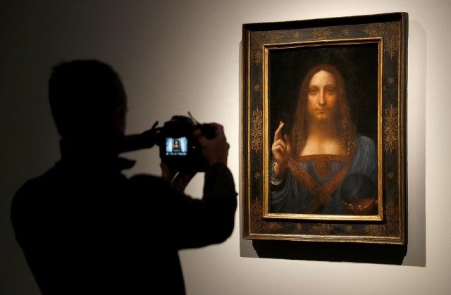 Miembros del personal de Christie's posan para fotos junto a la pintura "Salvator Mundi" de Leonardo da Vinci, que será subastada por Christie's en Nueva York en noviembre, en Londres, Gran Bretaña, el 24 de octubre de 2017. REUTERS / Peter Nicholls NO RESALES. SIN ARCHIVOS