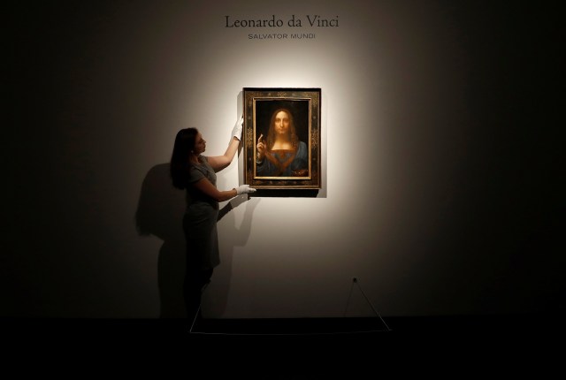 Miembros del personal de Christie posan para fotos junto a la pintura "Salvator Mundi" de Leonardo da Vinci, que será subastada por Christie's en Nueva York en noviembre, en Londres, Gran Bretaña, el 24 de octubre de 2017. REUTERS / Peter Nicholls NO RESALES. SIN ARCHIVOS