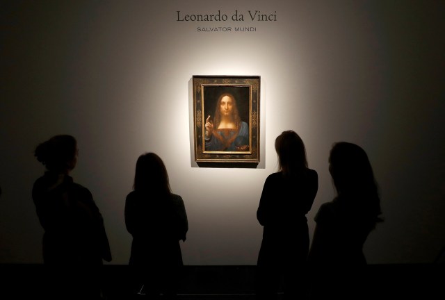 Miembros del personal de Christie posan para fotos junto a la pintura "Salvator Mundi" de Leonardo da Vinci, que será subastada por Christie's en Nueva York en noviembre, en Londres, Gran Bretaña, el 24 de octubre de 2017. REUTERS / Peter Nicholls NO RESALES. SIN ARCHIVOS