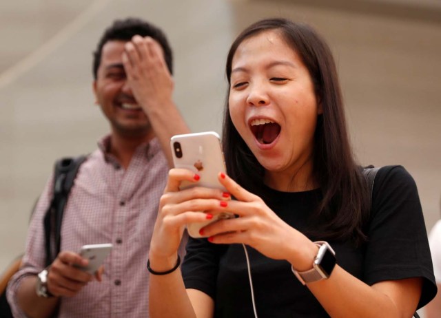 People try the Animoji feature on iPhone X during its launch at the Apple store in Singapore November 3, 2017. REUTERS/Edgar Su