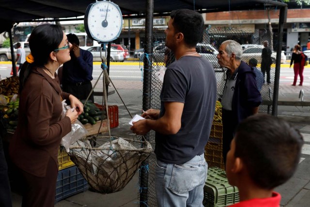 A vendor weights vegetables at a street market in Caracas, Venezuela November 3, 2017. Picture taken November 3, 2017. REUTERS/Marco Bello