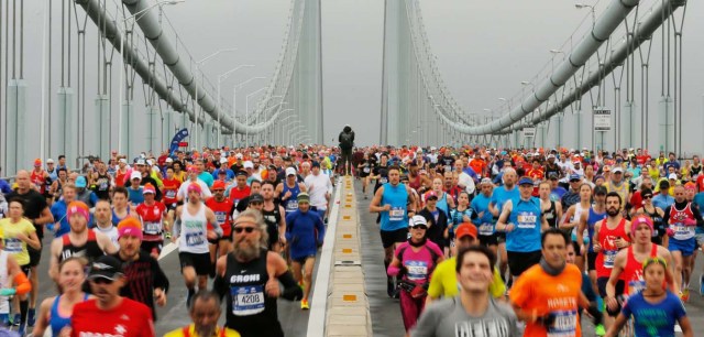 A photojournalist stands on the center divider as the first wave of runners make their way across the Verrazano-Narrows Bridge during the start of the New York City Marathon in New York, U.S., November 5, 2017. REUTERS/Lucas Jackson
