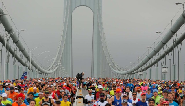 A photojournalist stands on the center divider as the first wave of runners make their way across the Verrazano-Narrows Bridge during the start of the New York City Marathon in New York, U.S., November 5, 2017. REUTERS/Lucas Jackson