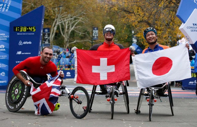 The winners of the wheelchair race, 2nd place winner John Charles Smith of Uinted Kingdom (L), winner Marcel Hug of Switzerland (C) and 3rd place winner Sho Watanabe of Japan (R) celebrate at the finish line of the New York City Marathon after winning the wheelchair race in Central Park in New York, U.S., November 5, 2017. REUTERS/Brendan McDermid