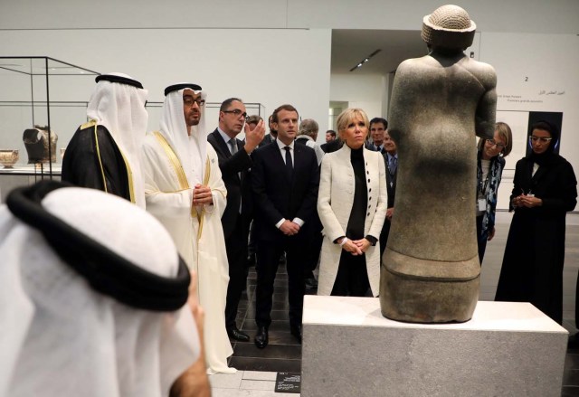 Abu Dhabi Crown Prince Mohammed bin Zayed Al-Nahyan (2ndL), President-Director of the Louvre Museum, Jean-Luc Martinez (3rdL) French President Emmanuel Macron (2ndR) and his wife Brigitte Macron (R) look at a piece of art as they visit the Louvre Abu Dhabi Museum in Abu Dhabi, UAE, November 8, 2017. Picture taken November 8, 2017. REUTERS/Ludovic Marin/Pool