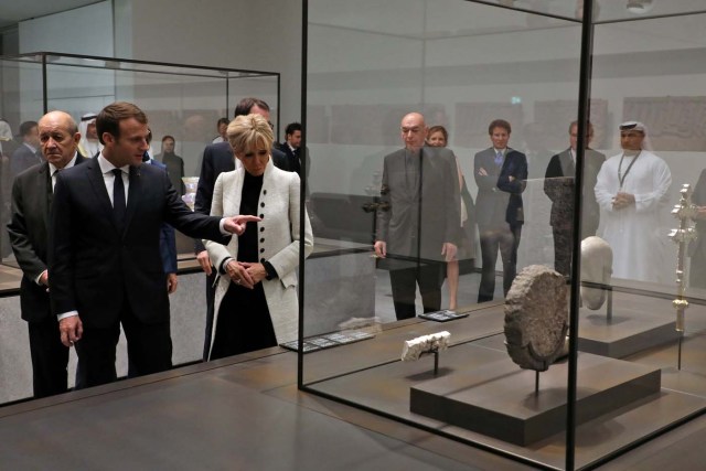 French President Emmanuel Macron (2ndL) and his wife Brigitte Macron react as they look at a piece of art as they visit the Louvre Abu Dhabi Museum during its inauguration in Abu Dhabi, UAE, November 8, 2017. Picture taken November 8, 2017. REUTERS/Ludovic Marin/Pool