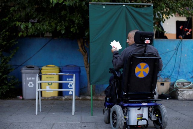 A citizen leaves a booth after voting at a polling station in Santiago, Chile, November 19, 2017. REUTERS/Carlos Garcia Rawlins