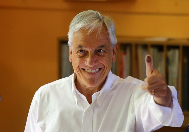 Chilean presidential candidate Sebastian Pinera shows his inked thumb to the media before voting during the presidential election, at a public school in Santiago, Chile November 19, 2017. REUTERS/Ivan Alvarado