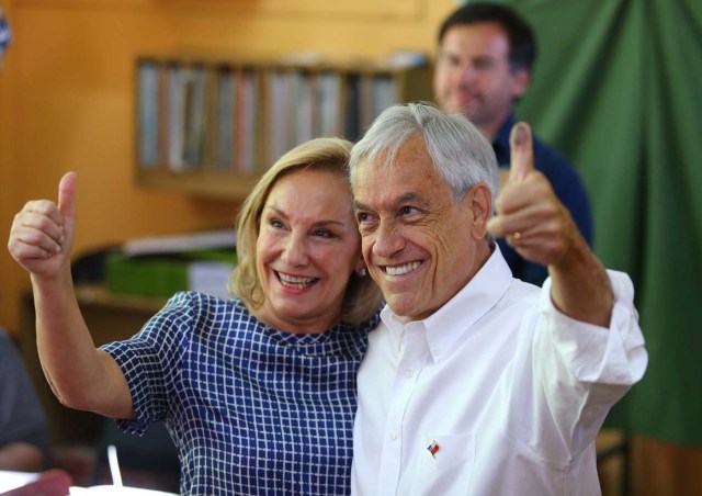 Chilean presidential candidate Sebastian Pinera waves to the media next to his wife Cecilia Morel before voting during the presidential election, at a public school in Santiago, Chile November 19, 2017. REUTERS/Ivan Alvarado