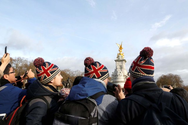 Tourists take pictures outside Buckingham Palace after Prince Harry announced his engagement to Meghan Markle, in London, Britain, November 27, 2017. REUTERS/Darrin Zammit Lupi