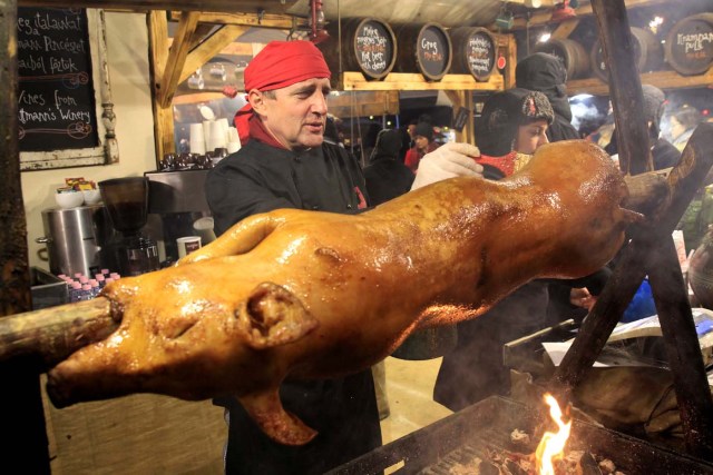 A vendor prepares roast pig at the Budapest Christmas Fair at Vorosmarty Square in downtown Budapest, Hungary, November 27, 2017. REUTERS/Bernadett Szabo