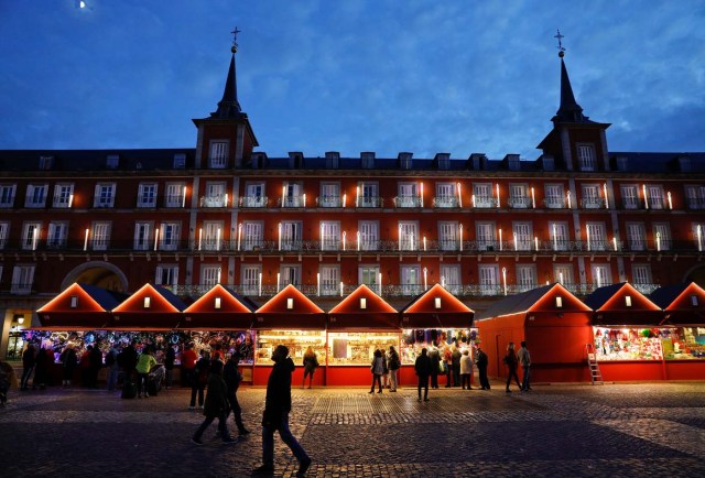 Christmas market stalls and the facade of the Plaza Mayor are illuminated at dusk in Madrid, Spain, November 27, 2017. REUTERS/Paul Hanna