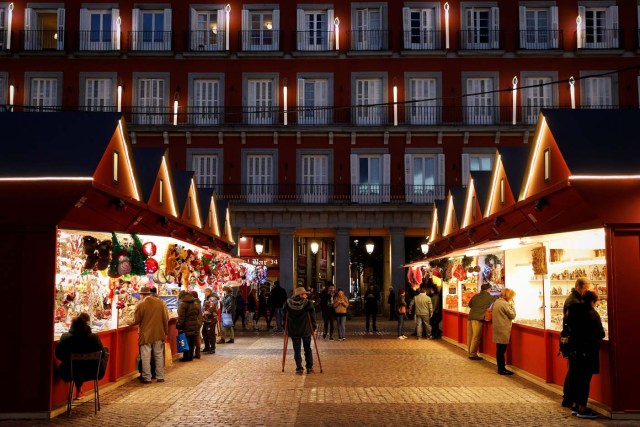 Christmas market stalls and the facade of the Plaza Mayor are illuminated at dusk in Madrid, Spain, November 27, 2017. REUTERS/Paul Hanna