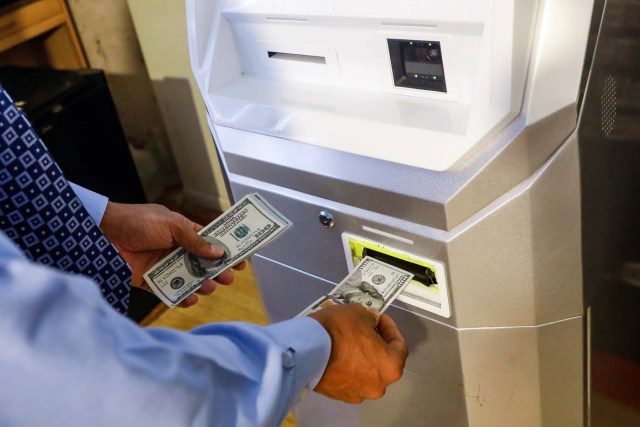 A man feeds money into a Bitcoin ATM at the Bitcoin Center NYC in New York, U.S., November 27, 2017. REUTERS/Brendan McDermid