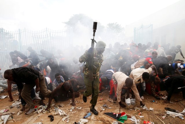 People fall as police fire tear gas to try control a crowd trying to force their way into a stadium to attend the inauguration of President Uhuru Kenyatta at Kasarani Stadium in Nairobi, Kenya November 28, 2017. REUTERS/Baz Ratner TPX IMAGES OF THE DAY
