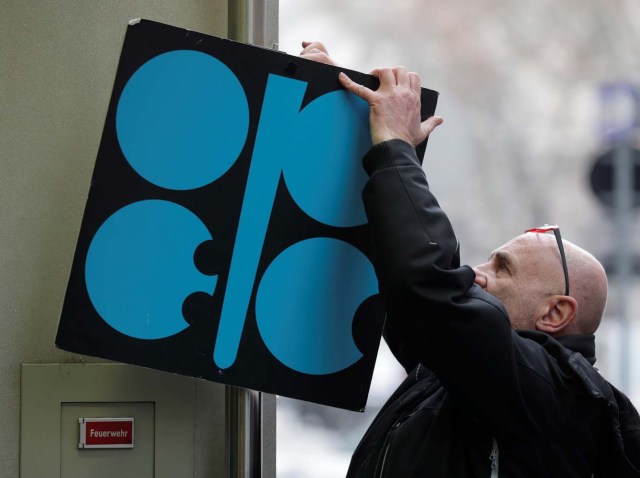 Un hombre acomoda un cartel con el logotipo de la OPEP en la entrada de la sede de la organización antes de una reunión de ministros de petróleo, en Viena. 29 de noviembre de 2017. REUTERS/Heinz-Peter Bader