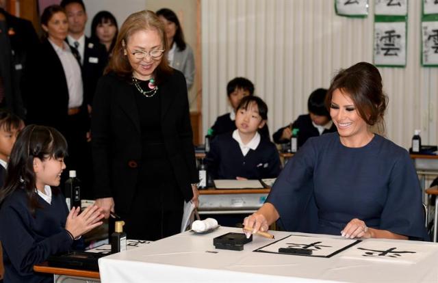 La primera dama estadounidense Melania Trump (R) escribe caligrafía con la ayuda de una niña de la escuela (L) mientras asiste a una clase de caligrafía con Akie Abe (C), esposa del primer ministro japonés Shinzo Abe, en la escuela primaria Kyobashi Tsukiji en Tokio, Japón , 06 de noviembre de 2017. La visita del presidente Trump a Japón es la primera parada de su gira de 12 días por Asia. Después de Japón, Trump visitará Corea del Sur, China, Vietnam y Filipinas. (Tokio, Corea del Sur, Filipinas, Japón, Estados Unidos) EFE / EPA / TOSHIFUMI KITAMURA / PISCINA