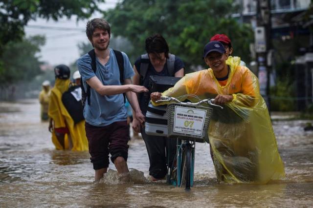  Residentes caminan por las calles inundadas de Hoi An (Vietnam) hoy, 6 de noviembre de 2017. Al menos 27 personas murieron y otras 22 se encuentran desaparecidas debido a las fuertes lluvias e inundaciones causadas por el tifón Damrey en la zona central de Vietnam. EFE/ Wallace Woon