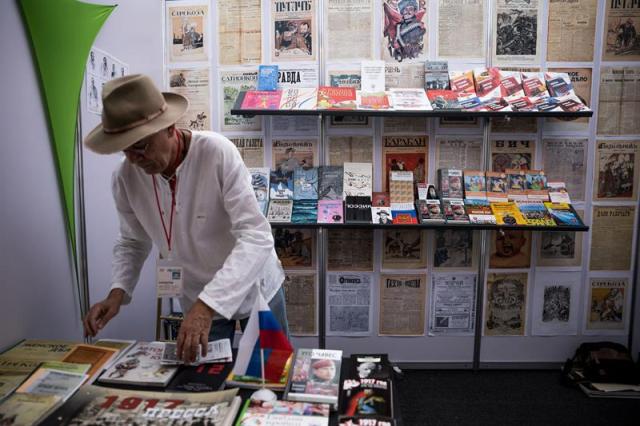 Un hombre acomoda libros en la caseta de Rusia este, viernes 10 de noviembre de 2017, durante la Feria Internacional del Libro de Venezuela (Filven), en la ciudad de Caracas (Venezuela). Los libros del difunto presidente Hugo Chávez en español y traducidos al ruso, las biografías y semblanzas de Lenin y las retrospectivas de los 100 años de la revolución soviética son, junto a la caseta de Corea del Norte, las estrellas de la Feria Internacional del Libro de Venezuela (Filven), que arrancó este jueves en Caracas. EFE/MIGUEL GUTIERREZ