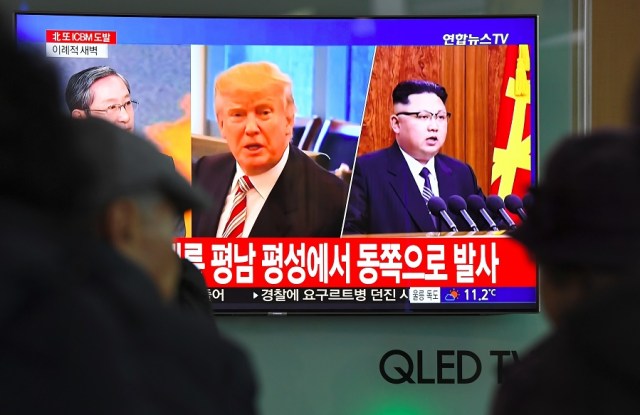 People watch a television news screen showing pictures of US President Donald Trump (C) and North Korean leader Kim Jong-Un (R) at a railway station in Seoul on November 29, 2017. North Korea test fired what appeared to be an intercontinental ballistic missile on November 29, in a major challenge to US President Donald Trump after he slapped fresh sanctions on Pyongyang and declared it a state sponsor of terrorism. / AFP PHOTO / JUNG Yeon-Je