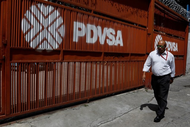 Imagen de archivo. Un hombre pasa frente a una puerta con el logo de la petrolera estatal PDVSA en Caracas, Venezuela el 3 de noviembre de 2017. REUTERS / Marco Bello