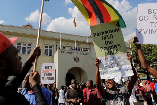 Manifestantes protestan en las inmediaciones del Parlamento en Harare (Zimbabue) hoy, 21 de noviembre de 2017. El Parlamento celebra hoy una sesión para tratar una moción de censura contra el presidente, Robert Mugabe. EFE/ Kim Ludbrook