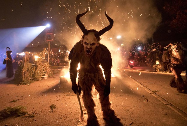 A participant performs during a procession of 'Krampus' monsters in Schwadorf, Austria on November 24, 2017. Krampus is traditionally the evil sidekick of Santa, sent to frighten naughty children and "evil spirits" in the run-up for Christmas. / AFP PHOTO / ALEX HALADA