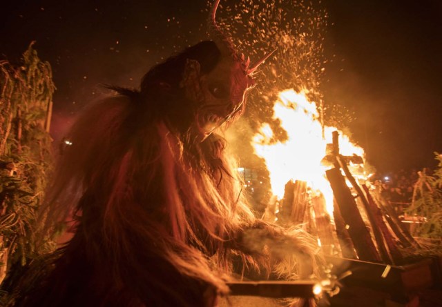 A participant performs during a procession of 'Krampus' monsters in Schwadorf, Austria on November 24, 2017. Krampus is traditionally the evil sidekick of Santa, sent to frighten naughty children and "evil spirits" in the run-up for Christmas. / AFP PHOTO / ALEX HALADA