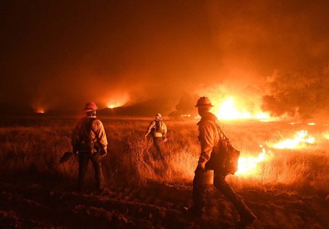 Firefighters light backfires as they try to contain the Thomas wildfire which continues to burn in Ojai, California, on December 9, 2017. Brutal winds that fueled southern California's firestorm finally began to ease Saturday, giving residents and firefighters hope for respite as the destructive toll of multiple blazes came into focus. / AFP PHOTO / MARK RALSTON