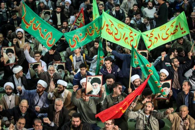 Iranians chant slogans as they march in support of the government near the Imam Khomeini grand mosque in the capital Tehran on December 30, 2017. Tens of thousands of regime supporters marched in cities across Iran in a show of strength for the regime after two days of angry protests directed against the country's religious rulers.  / AFP PHOTO / TASNIM NEWS / HAMED MALEKPOUR