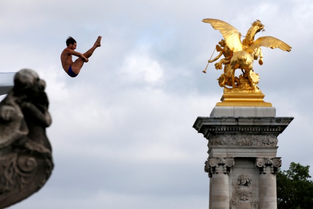 A participant dives from the Pont Alexandre III bridge into the River Seine in Paris, France, June 23, 2017. Paris transformed into a giant Olympic park, to celebrate International Olympic Day with a variety of sporting events for the public, as the city bids to host the 2024 Olympic and Paralympic Games. REUTERS/Jean-Paul Pelissier/File Photo  SEARCH "POY SPORT" FOR THIS STORY. SEARCH "REUTERS POY" FOR ALL BEST OF 2017 PACKAGES.    TPX IMAGES OF THE DAY