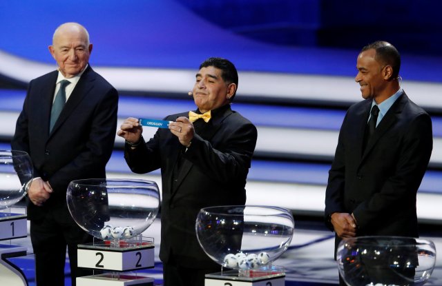 Soccer Football - 2018 FIFA World Cup Draw - State Kremlin Palace, Moscow, Russia - December 1, 2017 Diego Maradona pulls out Uruguay during the draw as Nikita Simonyan and Cafu look on REUTERS/Sergei Karpukhin