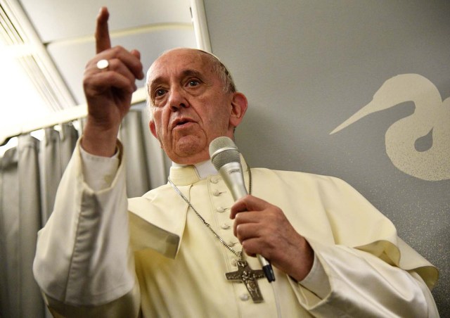 Pope Francis gestures during a news conference on board of the plane during his flight back from a trip to Myanmar and Bangladesh, December 2, 2017. REUTERS/Vincenzo Pinto/Pool