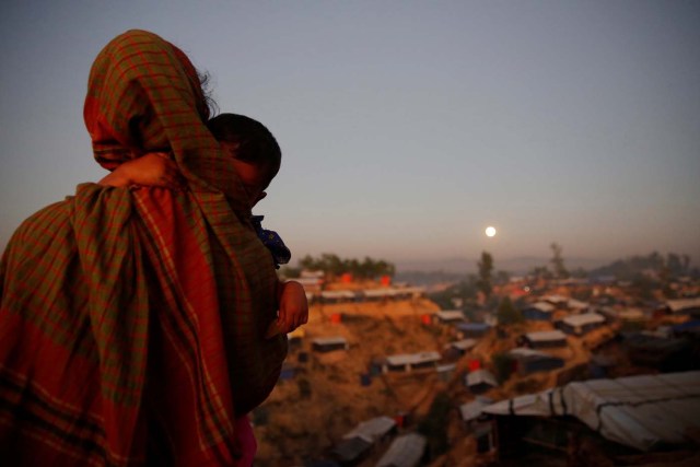 A Rohingya refugee looks at the full moon with a child in tow at Balukhali refugee camp near Cox's Bazar, Bangladesh, December 3, 2017. REUTERS/Susana Vera