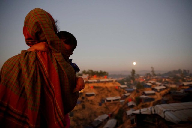 A Rohingya refugee looks at the full moon with a child in tow at Balukhali refugee camp near Cox's Bazar, Bangladesh, December 3, 2017. REUTERS/Susana Vera TPX IMAGES OF THE DAY