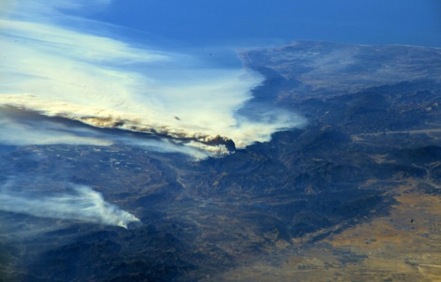 A photo taken from the International Space Station and moved on social media by astronaut Randy Bresnik shows smoke rising from wildfire burning in Southern California, U.S., December 6, 2017.  Courtesy @AstroKomrade/NASA/Handout via REUTERS   ATTENTION EDITORS - THIS IMAGE HAS BEEN SUPPLIED BY A THIRD PARTY.