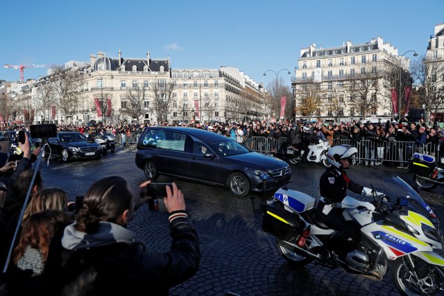 Motorcycle police escort the hearse carrying the coffin of late French singer and actor Johnny Hallyday on the Champs Elysees Avenue during a 'popular tribute' to the late French singer and actor Johnny Hallyday in Paris, France, December 9, 2017. REUTERS/Gonzalo Fuentes