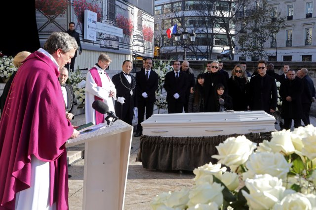 The son of late French singer Johnny Hallyday, David Hallyday (R), daughters Laura Smet (2ndR), Joy (3rdR) and Jade (5thR) his wife Laeticia, and his driver Patrick Roussel (C Rear) stand by the coffin outside the La Madeleine Church at the start of the funeral ceremony in Paris, France, December 9, 2017. REUTERS/Ludovic Marin/Pool
