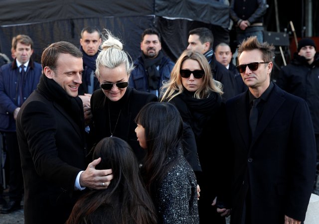 French President Emmanuel Macron hugs wife and chilfren of the late French singer Johnny Hallyday, (L-R) his daughter Joy Hallyday, Jade Hallyday, his wife Laeticia Hallyday, his daughter Laura Smet and his son David Hallyday as they arrive at the La Madeleine Church prior to the funeral ceremony for the late singer in Paris, France, December 9, 2017. REUTERS/Yoan Valat/Pool