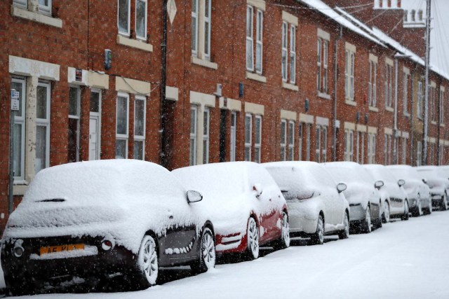 Snow piled high on parked cars is seen as the snow falls in Loughborough, Britain, December 10, 2017. REUTERS/Darren Staples