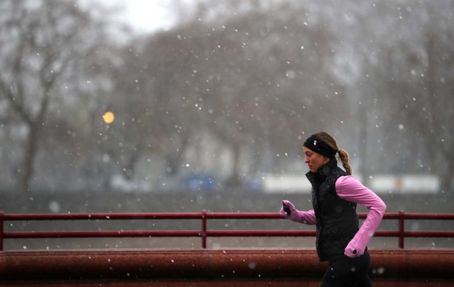 A woman runs through the snow in Battersea Park in London, Britain, December 10, 2017. REUTERS/Hannah McKay