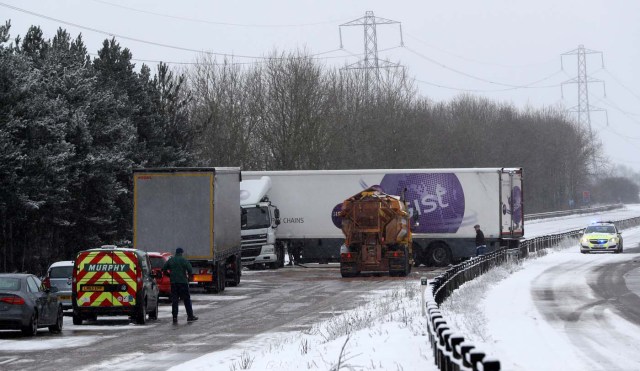 A crashed lorry on the A50 is tended to by police as the snow falls near Uttoxeter, Britain, December 10, 2017. REUTERS/Darren Staples