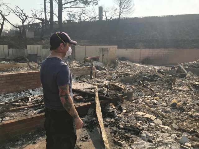 Richie Fredell, 38, a paramedic, looks at the remains of his childhood home in Ventura, California, U.S. December 8, 2017. Picture taken December 8, 2017. REUTERS/Ben Gruber