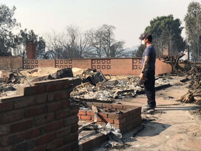 Richie Fredell, 38, a paramedic, looks at the remains of his childhood home in Ventura, California, U.S. December 8, 2017. Picture taken December 8, 2017. REUTERS/Ben Gruber