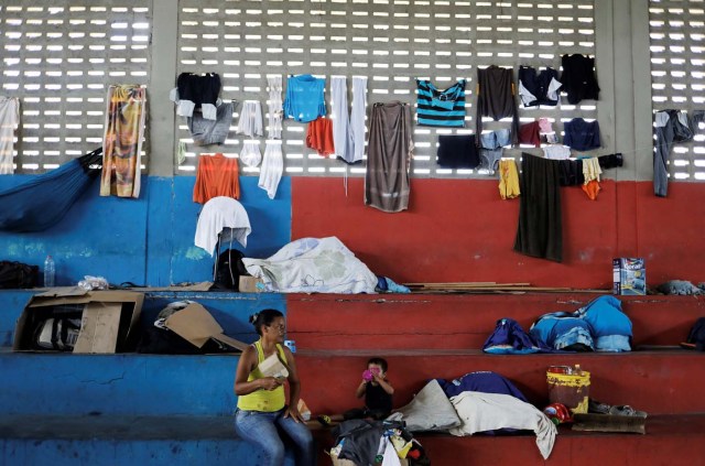 Venezuelan woman and her child sit at a gym which has turned into a shelter for Venezuelans and is run by Civil Defense with meals provided by Evangelical churches in Caimbe neighbourhood in Boa Vista, Roraima state, Brazil November 17, 2017. REUTERS/Nacho Doce SEARCH "VENEZUELAN MIGRANTS" FOR THIS STORY. SEARCH "WIDER IMAGE" FOR ALL STORIES.